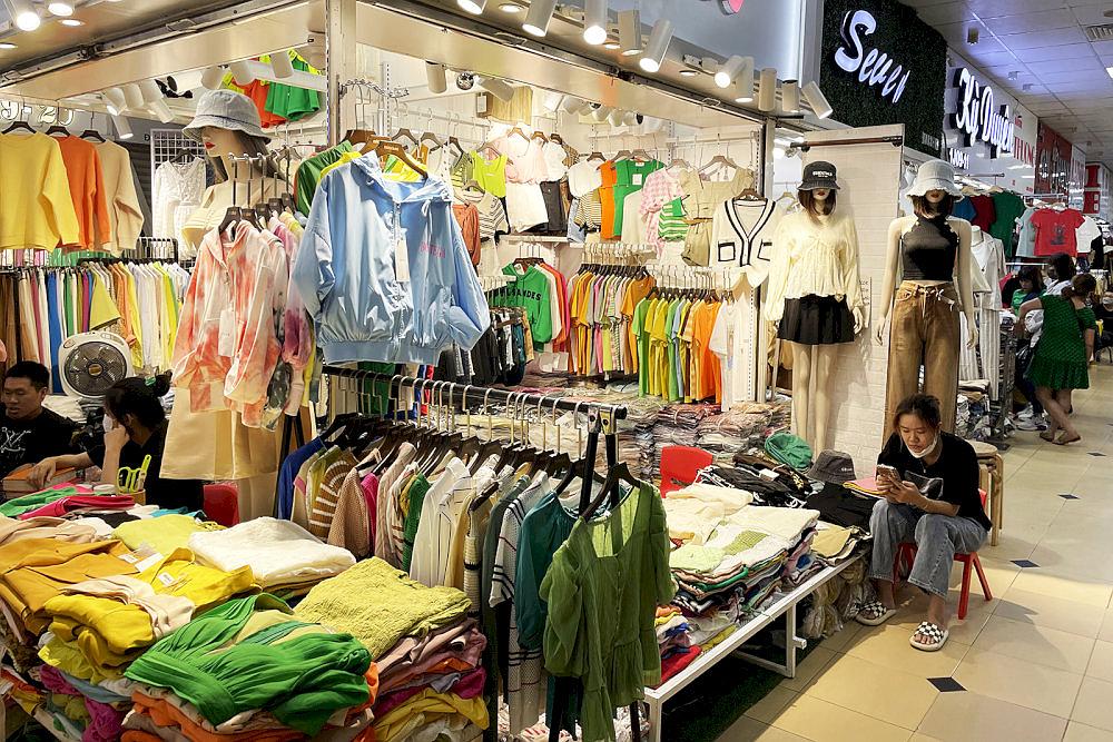 Racks of modern blouses and office wear hanging neatly under fluorescent lights